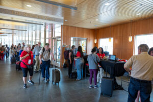 Alums at the Reunion Check-in desk, where they receive their namebadges, keys if they are staying on campus, and pre-ordered memento items. (Photo by Justin Hayworth/Grinnell College)