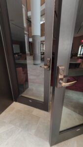 One of the doors leading to the HSSC multipurpose room, showing the opening mechanism which is a lever handle.