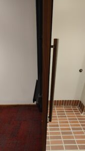View of entrance door to the auditorium with tiled floor at exterior and loop low/flat carpet inside auditorium.