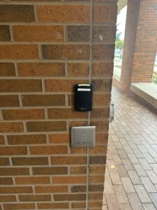 The grey square with the faded blue print stating push to open is the push button door opener. 