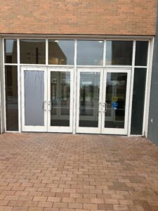The right most door in the set of doors is the one that has the automatic door opener. The interior door has a delay of approximately 4 seconds from the time of pushing the button on the exterior of the building to open the door. 
