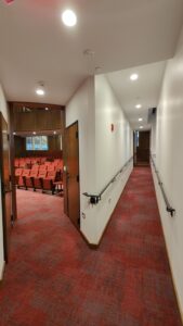 Ramp leading to front of audience seating area in HSSC Auditorium, continuing to back seating area if you proceed past the first doors.