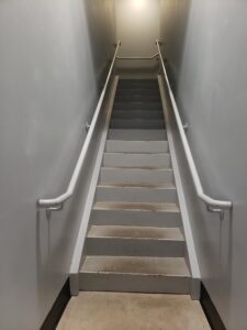 Stairs to upstairs bathroom, concrete, no treads, handle bars on both sides