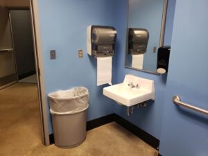 Bathroom layout showing sink with paper towels and waste basket to the left of the sink