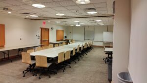 View of room as you enter from the doors closest to the elevator, with the standard set-up with the long tables in the center.